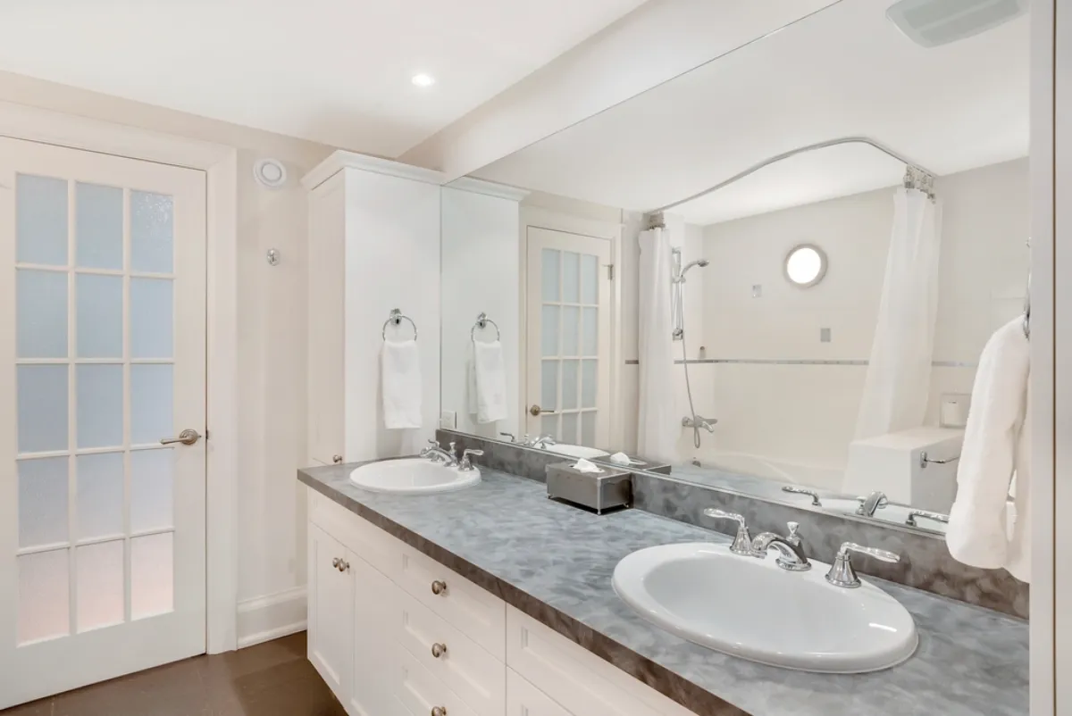 Bright bathroom with a white double vanity and marble countertop