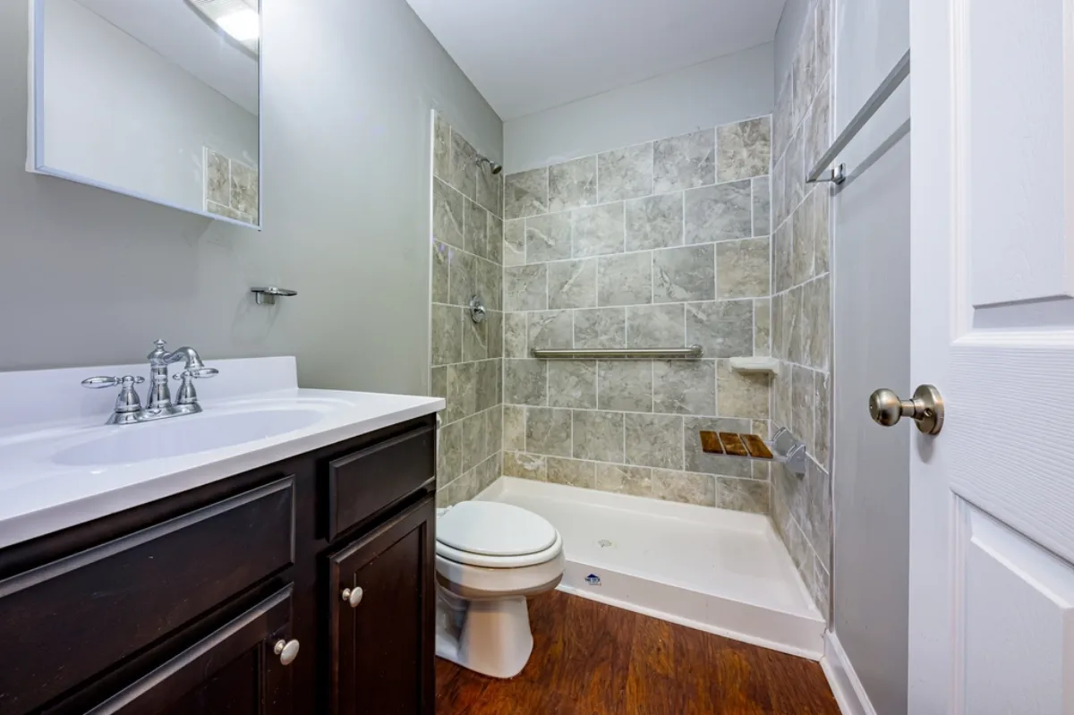 Tiled tub and shower with a vanity in a full bathroom