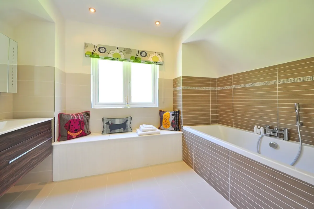 Bathtub with a tiled surround beside a window
