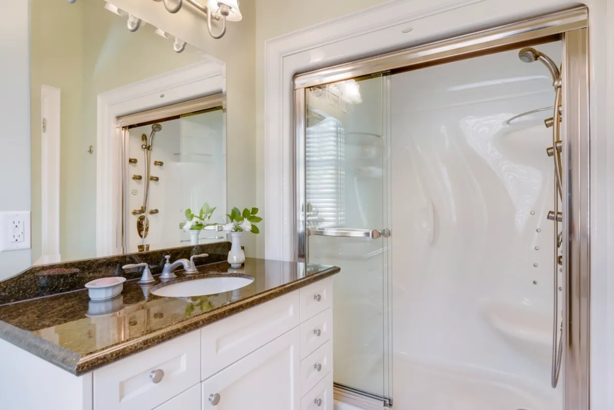 Bathroom vanity beside a glass-enclosed walk-in shower