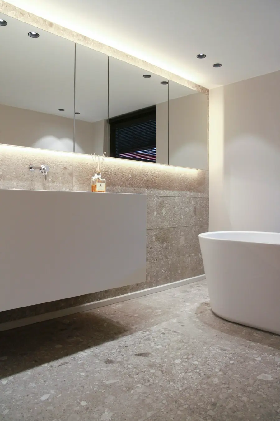 Modern spa-style bathroom with a freestanding tub and stone tile
