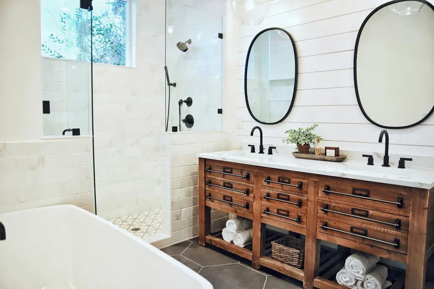 Farmhouse-style bathroom with a reclaimed-wood double vanity, glass shower, and freestanding tub
