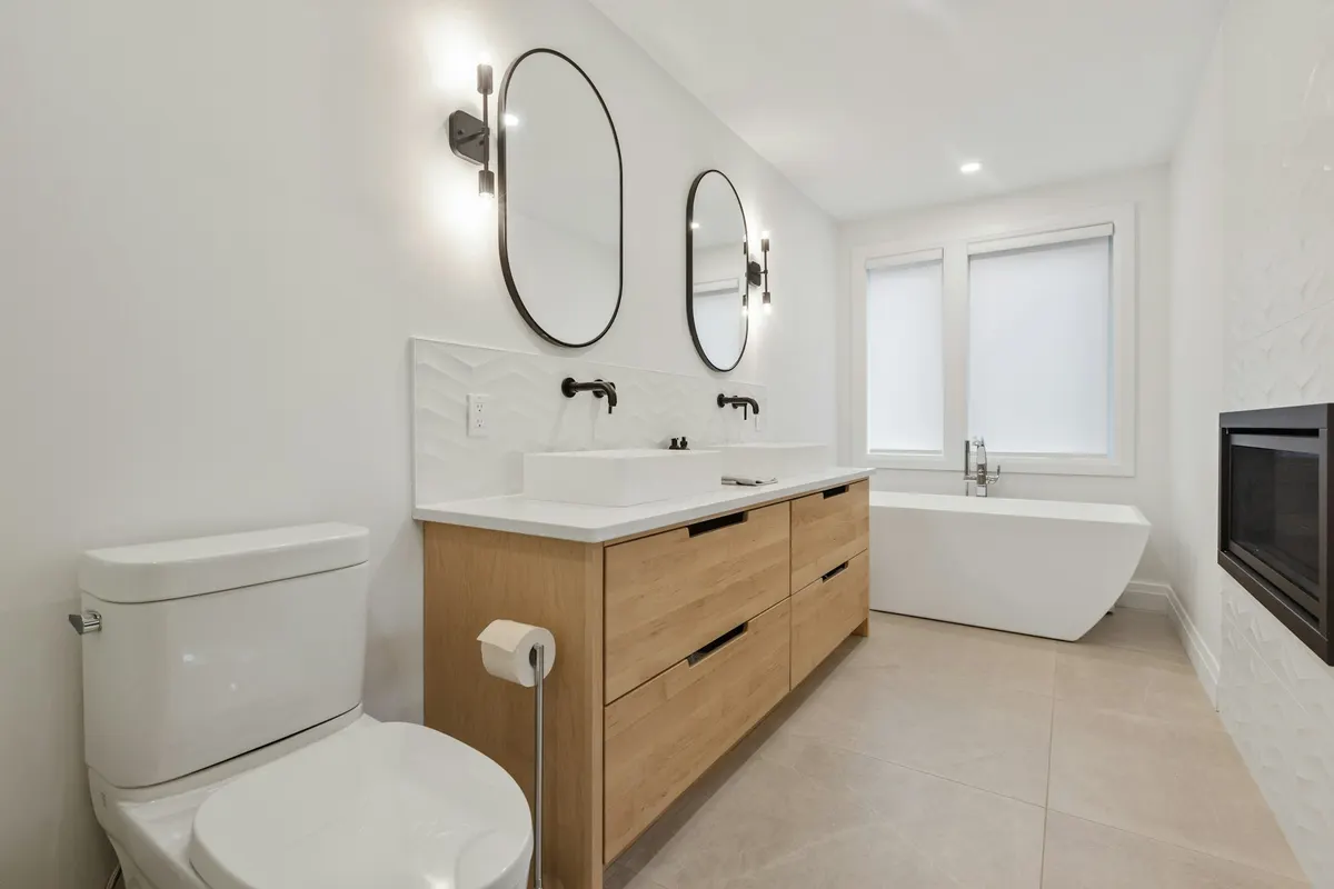 Bathroom remodel with a light-oak floating vanity and a freestanding tub