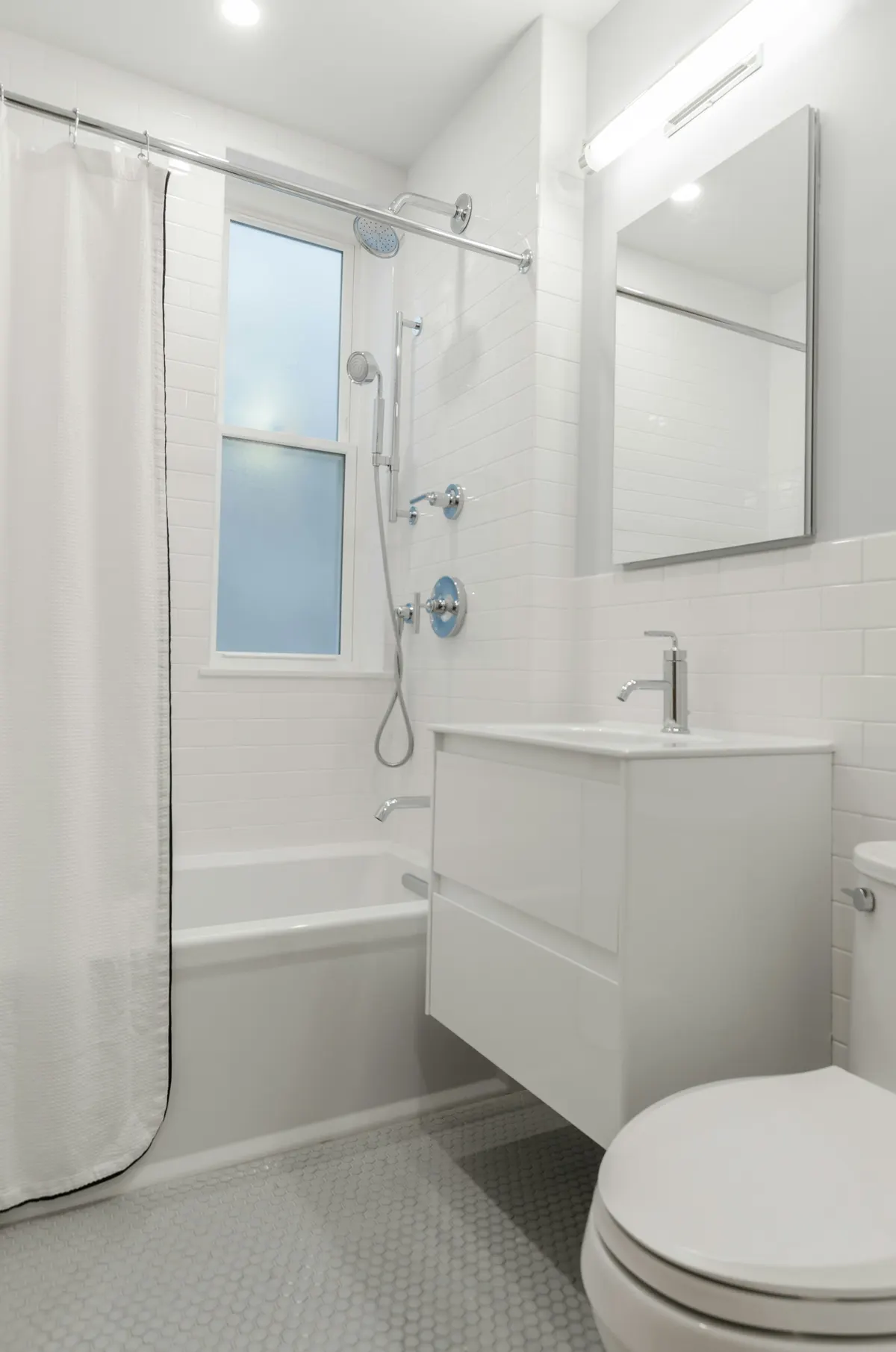 Classic bathroom with a white subway tub-and-shower and penny-tile floor