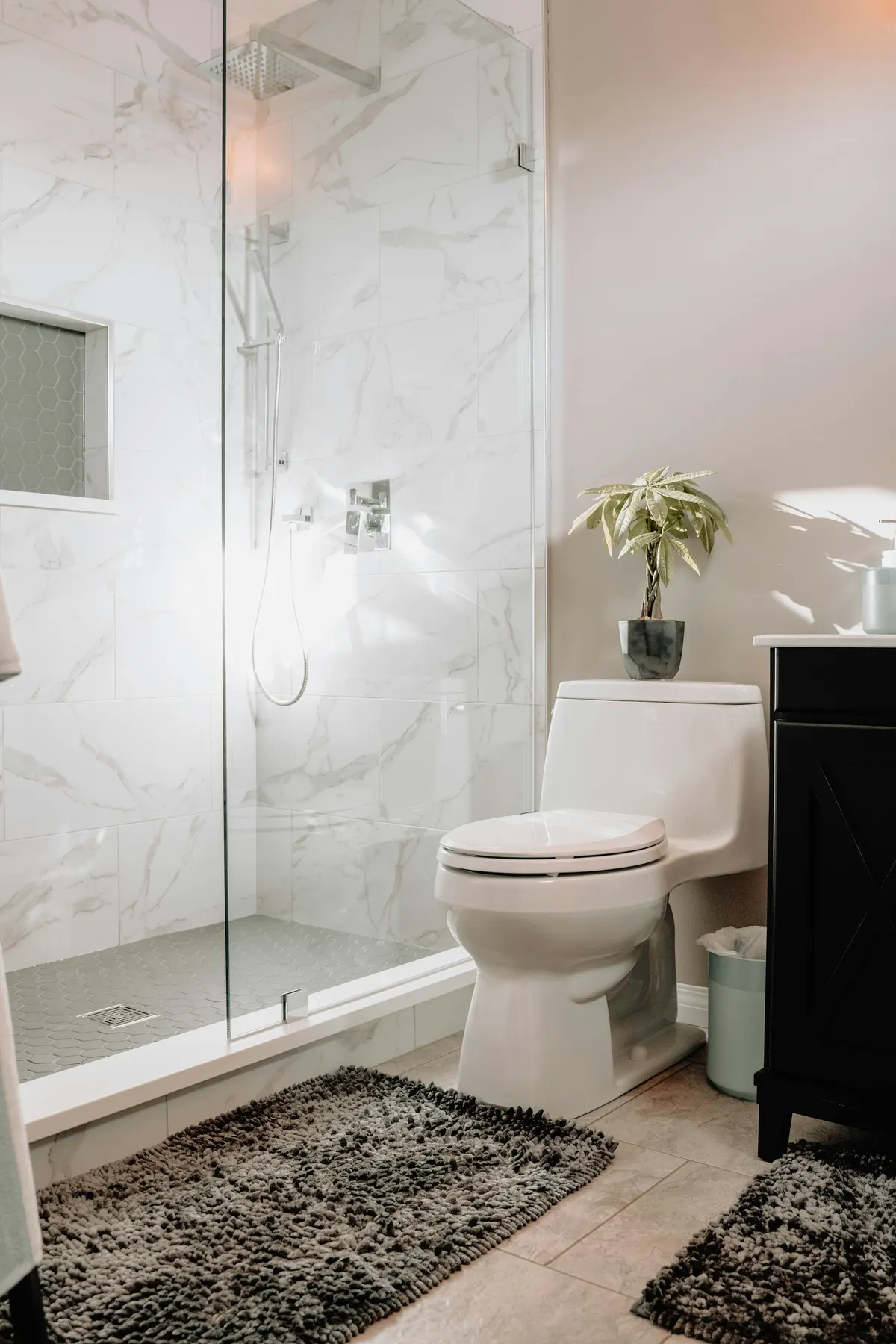 White marble walk-in shower with a frameless glass enclosure