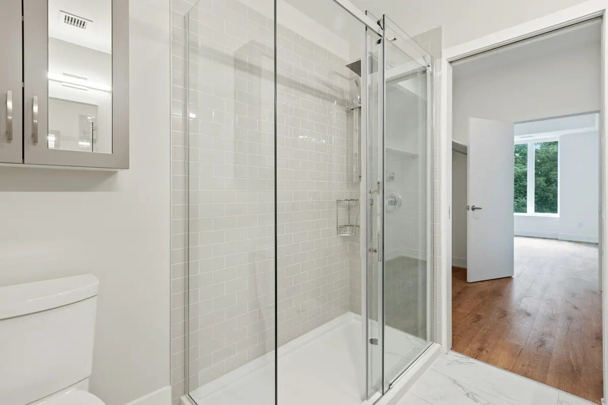 Walk-in shower with white subway tile and a glass sliding door