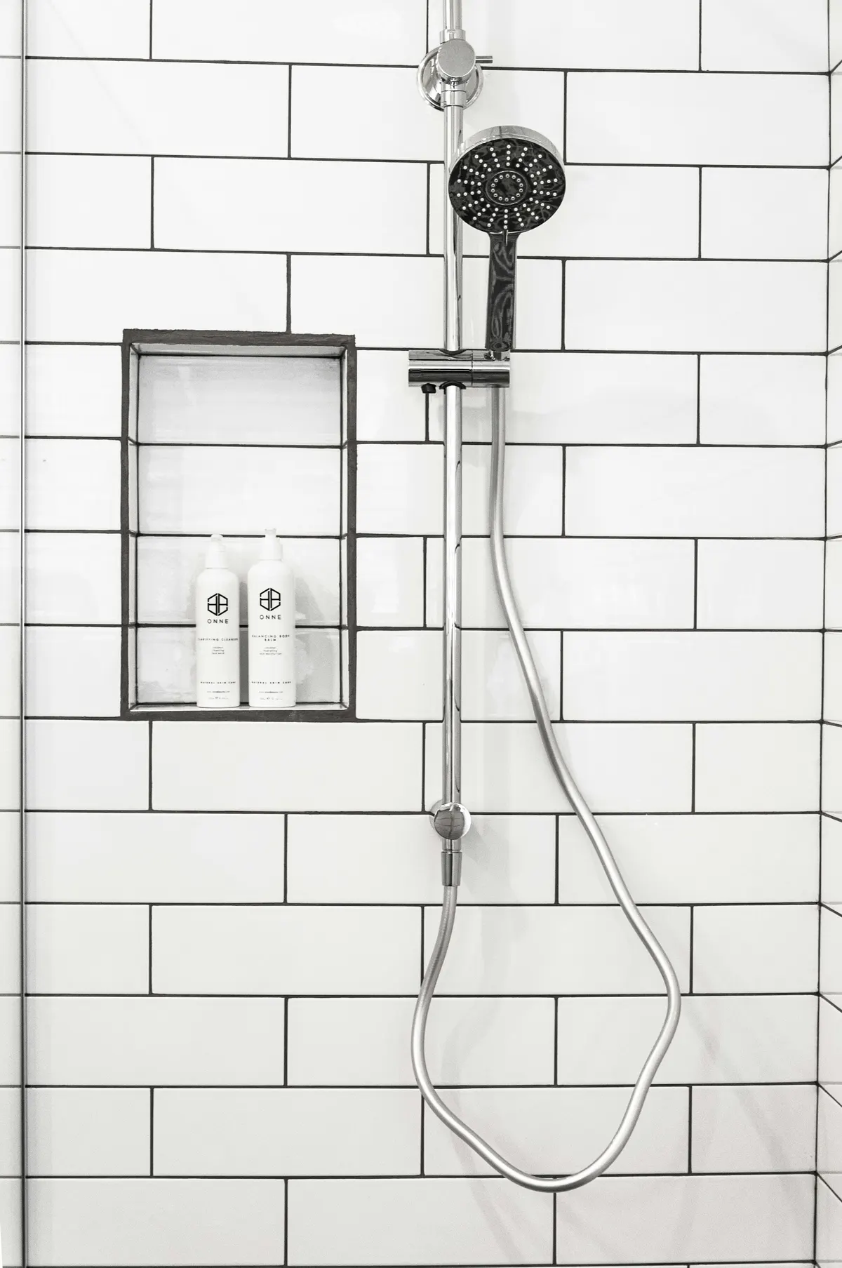 Tiled shower with white subway tile and a recessed niche